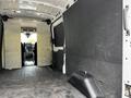 Interior of a 2022 Ford Transit van showing a spacious cargo area with black walls and a flat floor leading to the driver's seat in the front