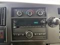 Dashboard controls of a 2019 Chevrolet Express featuring temperature knobs a digital clock and a stereo display with multiple buttons