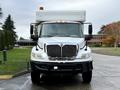 A 2011 International 4400 truck with a white box cargo area and a shiny front grille featuring the International logo