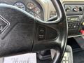 Close-up of the steering wheel and control panel of a 2011 International 7500 featuring buttons for cruise control and audio system dials