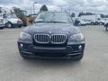A 2009 BMW X5 in dark color facing forward with its distinctive kidney grille and headlights visible