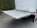 A silver 2018 Isuzu NPR with a lowered diamond plate liftgate at the rear