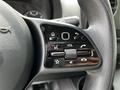 Close-up of the steering wheel control panel in a 2023 Mercedes-Benz Sprinter featuring buttons for volume navigation and settings