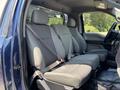 Interior view of a 2015 Ford F-150 showing the front seats with seatbelts and a spacious cabin layout