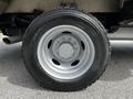 A close-up of a silver alloy wheel and tire from a 2016 Ford F-550 showing the tire tread and the wheel's bolt pattern