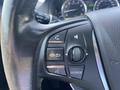Close-up of the steering wheel controls in a 2017 Acura TLX including buttons for phone, audio, and navigation