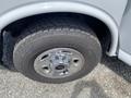 A close-up of a 2023 GMC Savana tire showcasing the silver alloy wheel and tread pattern