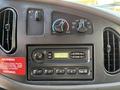 Dashboard of a 2007 Ford Econoline featuring climate control knobs and a CD player with digital clock displaying 235