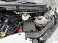 Engine compartment of a 2022 Ford Transit featuring various components including battery coolant reservoir and electrical connections