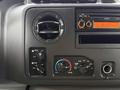 The dashboard controls of a 2014 Ford E-450 featuring climate control knobs an air vent dial and an audio system display