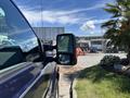 A side view of a 2014 Ford F-250 SD truck showcasing its large mirror and sleek body design