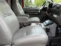 The interior of a 2007 Ford F-550 featuring two leather seats with armrests and a central console displaying various controls and a communication device