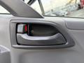 Interior door handle of a 2015 Isuzu NPR HD in a gray finish with a red button visible