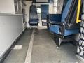 Interior of a 2014 Chevrolet Express showing two front seats and a middle aisle with textured flooring