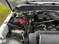 Engine bay of a 2015 Ford F-550 featuring visible components like the battery various hoses and wires and engine parts