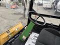 Interior view of a 1994 John Deere F1145 featuring a black steering wheel and green control panel with levers and buttons