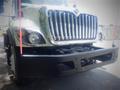 A 2012 International 7400 truck with a large chrome grille and prominent front bumper is displayed in the foreground