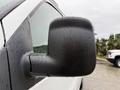 Close-up of the side mirror of a 2009 Chevrolet Express covered in raindrops