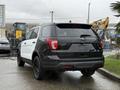 A 2019 Ford Explorer with a black and white color scheme parked in a lot showing the rear and side view of the vehicle