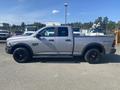 A silver 2021 RAM 1500 pickup truck with a crew cab and black wheels is shown from the side