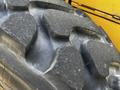 Close-up of a large, rugged tire from a 2010 John Deere 444K featuring deep treads designed for traction and durability
