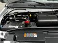 Close-up of the engine compartment of a 2021 Ford E-450 showcasing the battery and various components including hoses and connectors