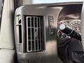 Close-up of the dashboard controls and air vent in a 2019 Chevrolet Express showing buttons for various features and a portion of the steering column