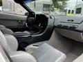 Interior of a 1992 Chevrolet Corvette featuring gray leather seats a sleek dashboard and steering wheel with various controls