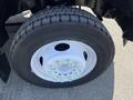 A close-up of a tire on a 2008 Ford F-450 SD showcasing the tread pattern and metallic wheel rim featuring multicolored securing mechanisms around the center
