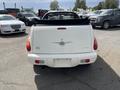 A white 2005 Chrysler PT Cruiser convertible with the top down showcasing its rear view taillights and bumper details