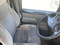Interior view of a 2008 Peterbilt 340 driver's seat and steering wheel showing a gray cloth seat with a textured pattern