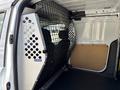 Interior of a 2021 Ford Transit Connect showing a metal safety partition and bare cargo area without any load or items inside