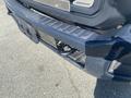 Close-up of a 2014 Ford F-250 SD front bumper with a tow hitch visible and a textured step area on the lower part of the bumper