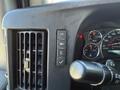 Dashboard controls of a 2019 Chevrolet Express featuring buttons for vehicle settings and gauges for speed and warning lights