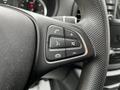 Close-up of the steering wheel controls of a 2023 Mercedes-Benz Metris featuring buttons for phone, audio, and volume adjustment