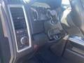 Dashboard of a 2021 RAM 1500 featuring control knobs and displays with a black interior and chrome accents