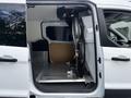 A 2016 Ford Transit Connect with the side door open revealing an empty cargo area and a metal partition behind the front seats