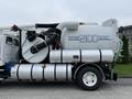 A 2006 Sterling L7500 truck equipped with a Vactor 2100 Series vacuum system featuring large tanks and hoses for suction and waste containment