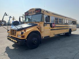 A 2007 Blue Bird Vision school bus with a bright yellow exterior and a stop sign extended on the side
