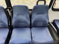 Two blue fabric seats with a textured pattern designed for a van or bus interior