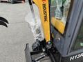 2024 AGT Industrial Yellow H13R Mini Excavator with a black arm and bucket showing plastic wrap on parts and control panel visible