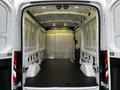 Interior view of a 2017 Ford Transit cargo van showing empty space with a flat floor and metal partition at the back