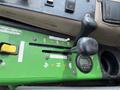 The control panel of a 2014 John Deere 1585 Terrain Cut featuring levers for 4WD control and axle speed along with a digital display and PTO switch