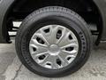 A close-up view of a silver wheel rim and black tire of a 2020 Ford Transit