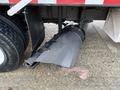 A black exhaust system attached to a 2006 Freightliner M2 106 truck with a textured surface and a metal plate visible on the side