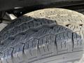 Close-up of a tire from a 2017 Ford Transit showcasing a deep tread pattern and signs of wear on the rubber surface