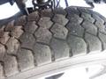 Close-up of a worn tire tread on a 2012 Ford F-550 showing deep grooves and cracks in the rubber surface