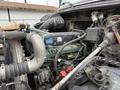 A 2012 Volvo VNL truck engine with visible components including hoses wires and an air intake system showcasing its mechanical details and design
