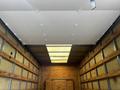 A 2021 Ford E-450 box truck interior featuring a smooth ceiling and wooden paneling along the sides with metal framing