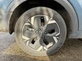 Close-up of a 2023 Kia Niro EV wheel showing a gray alloy rim and a black tire with tread patterns